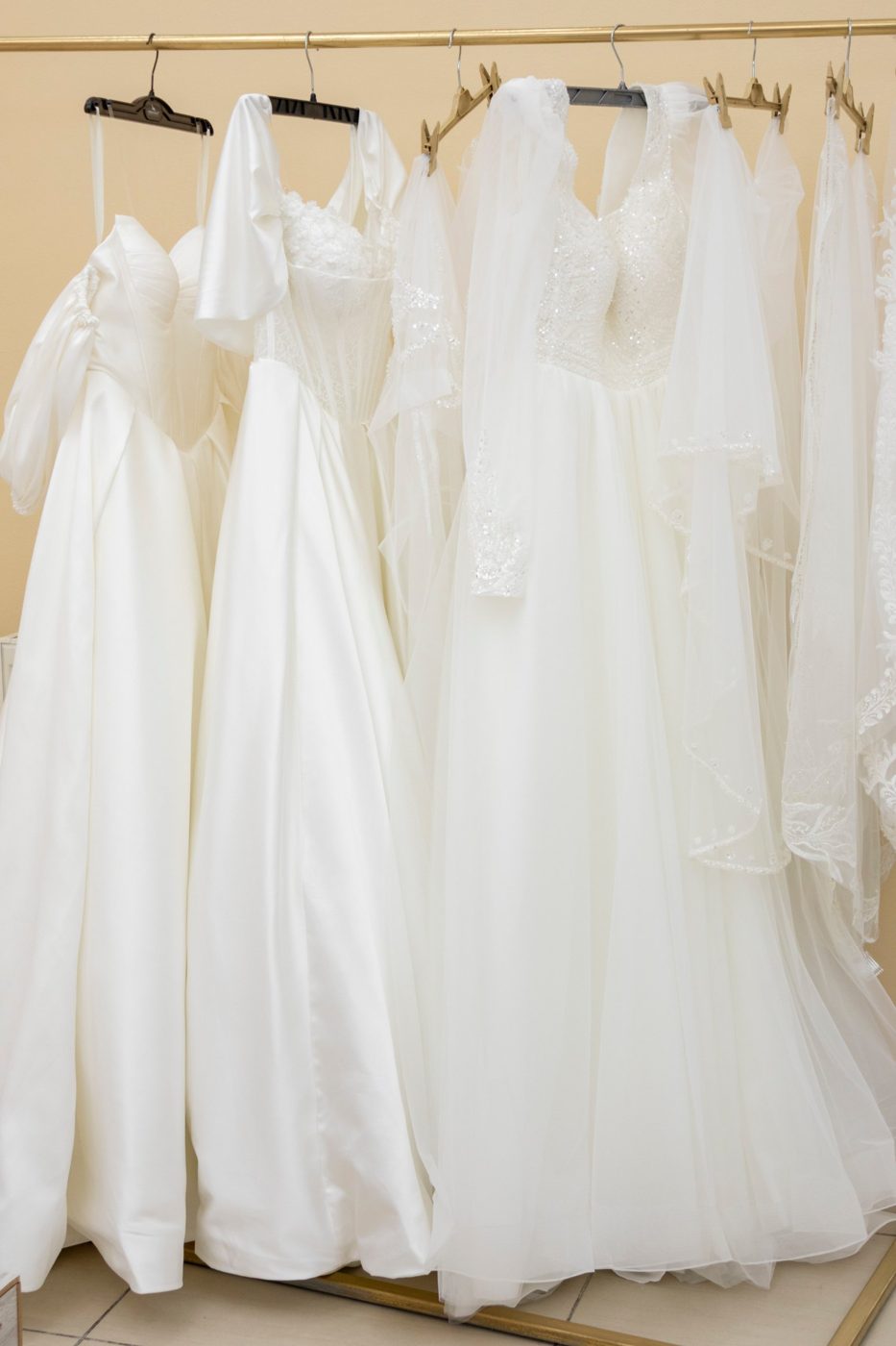 Rochii de mireasă pe stender în showroomul Vialli Sposa